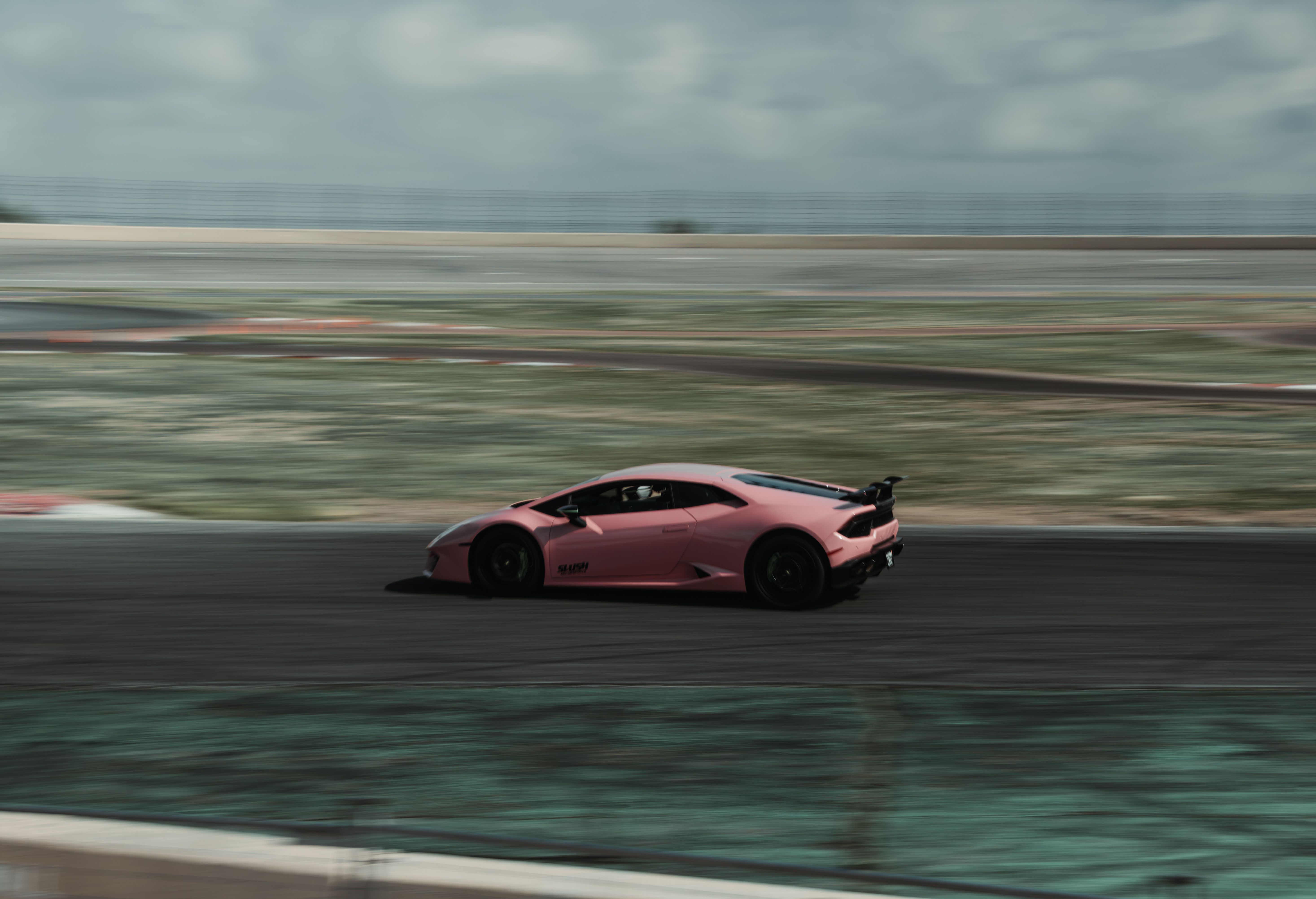 Pink Lamborghini Huracán cornering on a race track